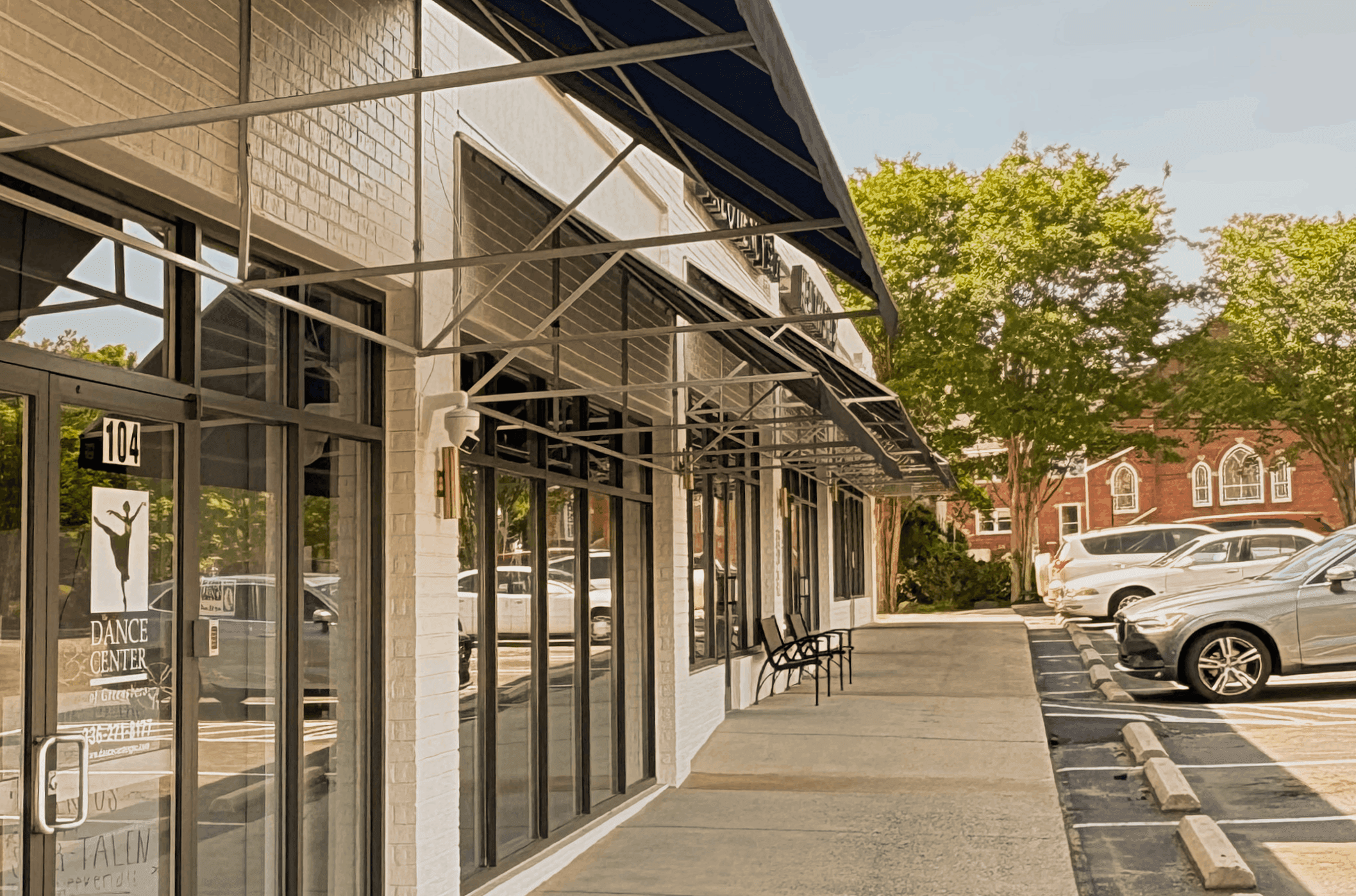 Multi-tenant retail storefront with awning and brick facade on a Southeast main street