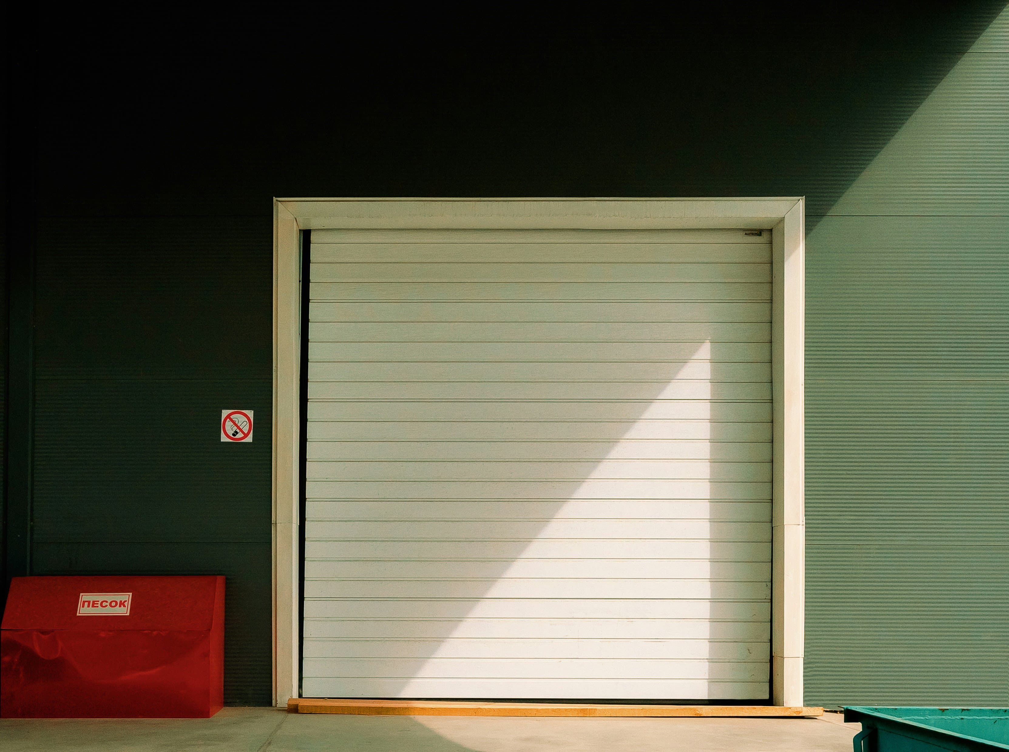 Industrial roll-up bay door with sunlight across its surface